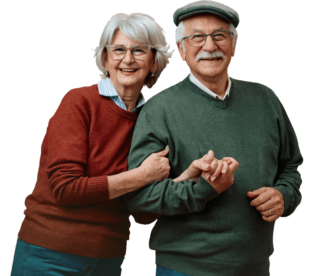 Smiling Elderly Couple in Sweaters Posing Arm in Arm at an Independent Living Community Smiling Elderly Couple in Sweaters Posing Arm in Arm at an Independent Living Community