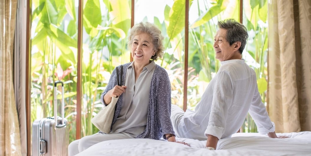 Smiling Elderly Couple Relaxing in Bright Apartment at Independent Facility